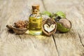 Walnut oil in glass of bottle, whole big peeled walnut kernel with thin shell on wooden background Royalty Free Stock Photo