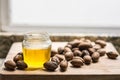 Walnut oil in a jar, some delicious nuts are on a wooden table Royalty Free Stock Photo