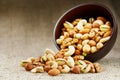 Walnut platter spilled out of the cup on the background of cloth from burlap. Nuts as structure and background, macro Royalty Free Stock Photo