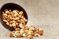 Walnut platter spilled out of the cup on the background of cloth from burlap. Nuts as structure and background, macro Royalty Free Stock Photo