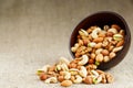 Walnut platter spilled out of the cup on the background of cloth from burlap. Nuts as structure and background, macro Royalty Free Stock Photo