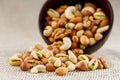 Walnut platter spilled out of the cup on the background of cloth from burlap. Nuts as structure and background, macro Royalty Free Stock Photo