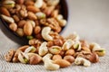 Walnut platter spilled out of the cup on the background of cloth from burlap. Nuts as structure and background, macro Royalty Free Stock Photo