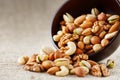 Walnut platter spilled out of the cup on the background of cloth from burlap. Nuts as structure and background, macro Royalty Free Stock Photo