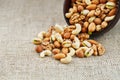 Walnut platter spilled out of the cup on the background of cloth from burlap. Nuts as structure and background, macro Royalty Free Stock Photo