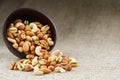 Walnut platter spilled out of the cup on the background of cloth from burlap. Nuts as structure and background, macro Royalty Free Stock Photo