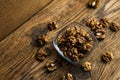 Walnut in a smale plate with scattered shelled nuts which standing on a wooden vintage table. Walnuts is a healthy