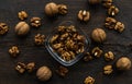 Walnut in a smale plate with scattered shelled nuts and whole nut which standing on a wooden vintage table. Walnuts is a