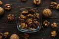 Walnut in a smale plate with scattered shelled nuts and whole nut which standing on a wooden vintage table. Walnuts is a