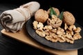 Walnut and walnut kernels on the plate on rustic wooden black background. Royalty Free Stock Photo