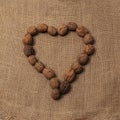 Walnuts arranged to form a heart. Rustic background of raw yuta canvas - delicious food Royalty Free Stock Photo