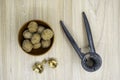 Walnuts in a bowl with a nutcracker next to it on the table. Flat lay. Royalty Free Stock Photo