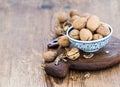 Walnuts in ceramic bowl and on cutting board with nutcracker over rustic wooden background Royalty Free Stock Photo