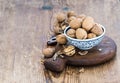 Walnuts in ceramic bowl and on cutting board with nutcracker over rustic wooden background Royalty Free Stock Photo