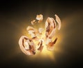 Walnuts crushed into pieces close-up isolated in the dark Royalty Free Stock Photo