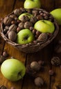 Walnuts with green apples mixed with a wicker basket Royalty Free Stock Photo