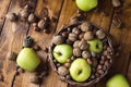 Walnuts with green apples mixed with a wicker basket Royalty Free Stock Photo