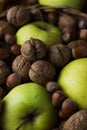 Walnuts with green apples mixed with a wicker basket Royalty Free Stock Photo