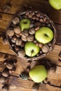 Walnuts with green apples mixed with a wicker basket Royalty Free Stock Photo