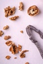 Walnuts heap food with half peeled nut, cracked nutshell, near to vintage nutcracker on white background