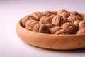 Walnuts heap food in wooden bowl on white background