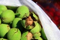 Walnuts in its green shells in plastic baskets