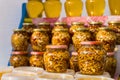 Walnuts in jars with honey syrup for sale at the fair, beautiful food background.