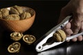 Walnuts on orange bowl and hand with nutcracker Royalty Free Stock Photo