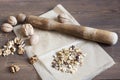 Walnuts in paper and wood battledore on a wooden background