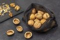 Walnuts in a reusable bag. Nut shells on the table, nut kernels on a black stone board Royalty Free Stock Photo
