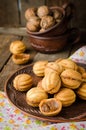 Walnuts shape cookies with condensed milk - dulce de leche in clay bowl on wooden rustic background. Selective focus