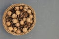 Walnuts in shell and pine cones in basket as Christmas table decoration Royalty Free Stock Photo