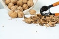 Walnuts, shells and nutcracker on a light background