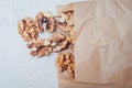 Walnuts sprinkled in paper bags spilled out onto a white kitchen table Royalty Free Stock Photo