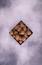 Walnuts on a square plate on bright textured surface, top view. Healthy nuts and seeds composition. Royalty Free Stock Photo