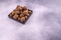 Walnuts on a square plate on bright textured surface, top view. Healthy nuts and seeds composition. Royalty Free Stock Photo