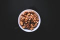 Walnuts in the white bowl on the black background taken from the top Royalty Free Stock Photo