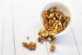 walnuts in the white bowl close. peeled walnuts on white colored old vintage wooden backdrop.