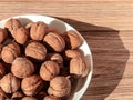 Walnuts in a white bowl on a wooden background Royalty Free Stock Photo