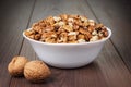 Walnuts in the white bowl on wooden table