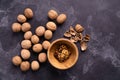 Walnuts in wooden bowl and on black slate surface. Healthy nuts and seeds composition. Royalty Free Stock Photo