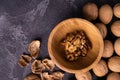 Walnuts in wooden bowl and on black slate surface. Healthy nuts and seeds composition. Royalty Free Stock Photo