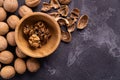 Walnuts in wooden bowl and on black slate surface. Healthy nuts and seeds composition. Royalty Free Stock Photo