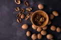 Walnuts in wooden bowl and on black slate surface. Healthy nuts and seeds composition. Royalty Free Stock Photo