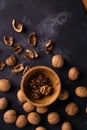 Walnuts in wooden bowl and on black slate surface. Healthy nuts and seeds composition. Royalty Free Stock Photo