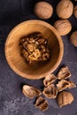 Walnuts in wooden bowl and on black slate surface. Healthy nuts and seeds composition. Royalty Free Stock Photo
