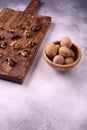 Walnuts in wooden bowl and on wooden carved board on bright textured surface. Healthy nuts and seeds composition. Royalty Free Stock Photo