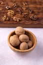 Walnuts in wooden bowl and on wooden carved board on bright textured surface. Healthy nuts and seeds composition. Royalty Free Stock Photo