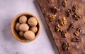 Walnuts in wooden bowl and on wooden carved board on bright textured surface. Healthy nuts and seeds composition. Royalty Free Stock Photo