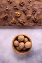 Walnuts in wooden bowl and on wooden carved board on bright textured surface. Healthy nuts and seeds composition. Royalty Free Stock Photo